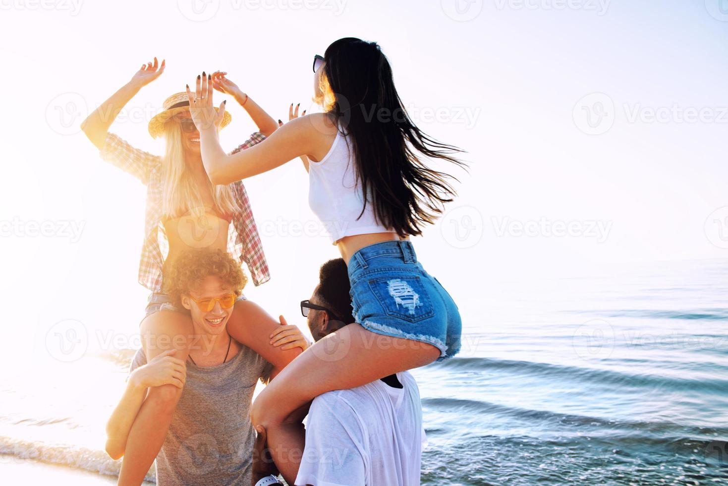 Happy smiling couples playing at the beach photo