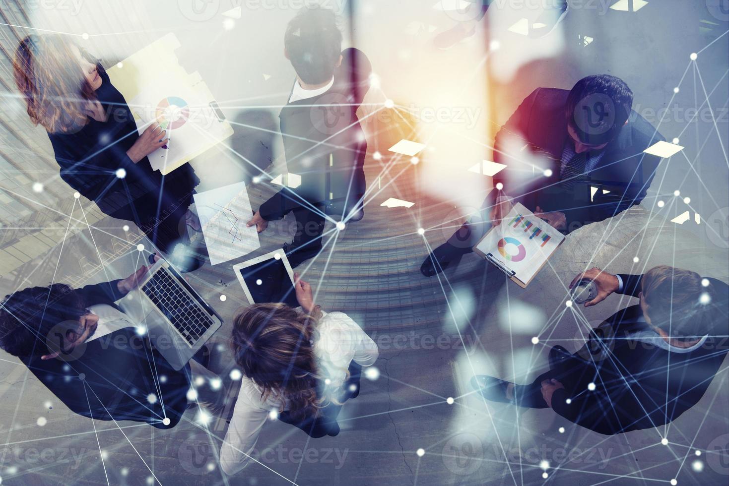 Team of business person works together on company statistics. Shooted from above. Concept of teamwork and partnership. double exposure photo