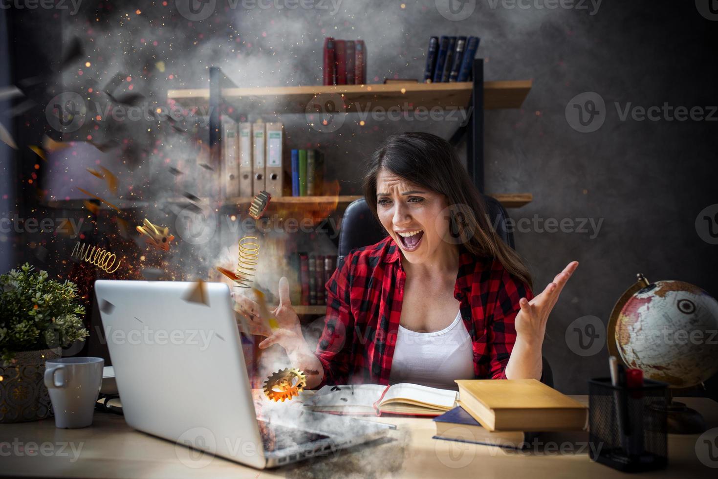 Stressed and angry woman with explosed computer due to overwork photo