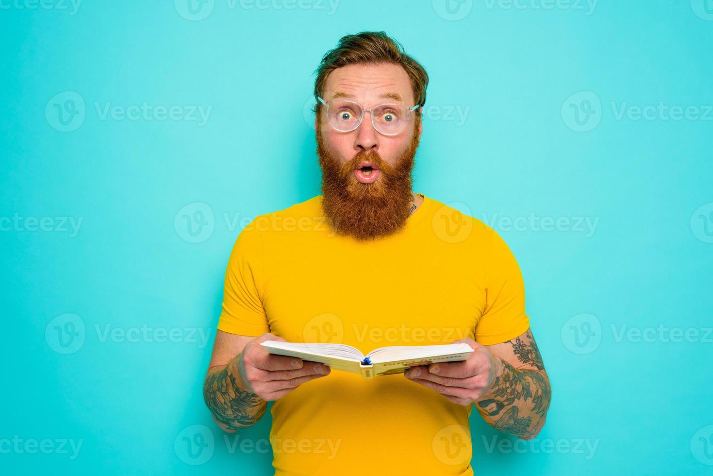 Man with yellow t-shirt and beard is surprised about something photo