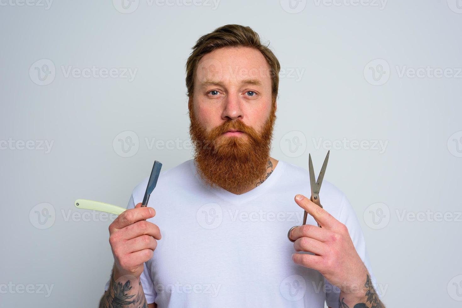 preocupado hombre con tijeras y espada es Listo a cortar el barba foto