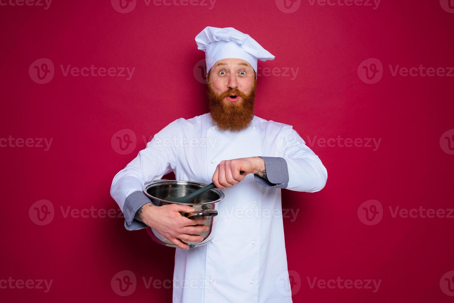 Happy chef with beard and red apron is ready to cook photo