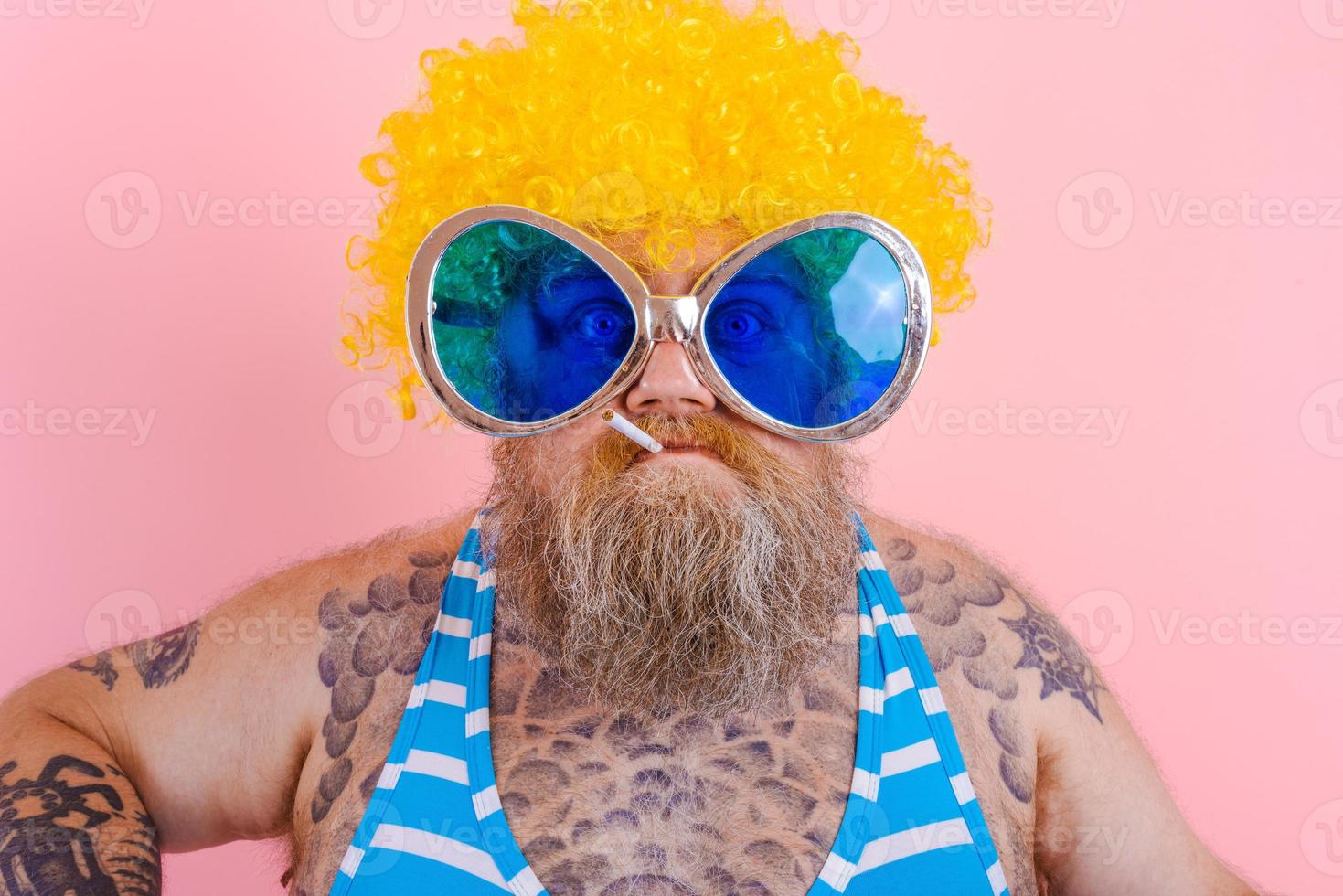 Fat serious man with beard and wig smokes cigarettes photo