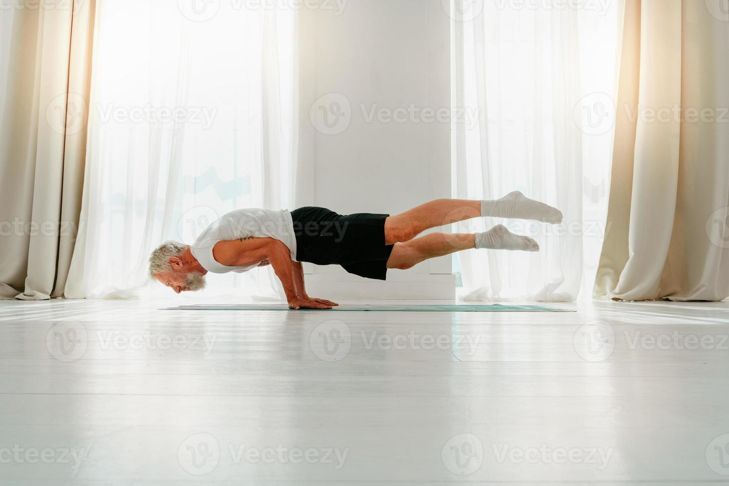 Sportive man does yoga exercise at home photo