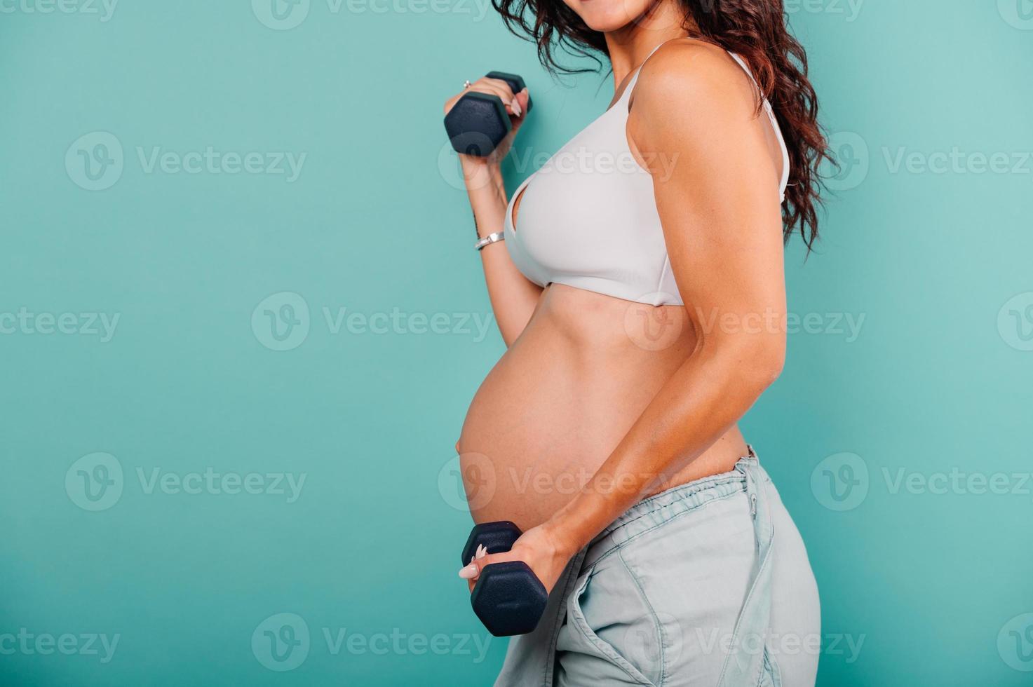 Pregnant woman expecting a child caresses her belly photo