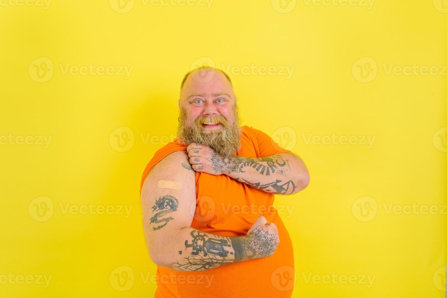 Happy man with beard and tattoos did the vaccine against covid-19 photo