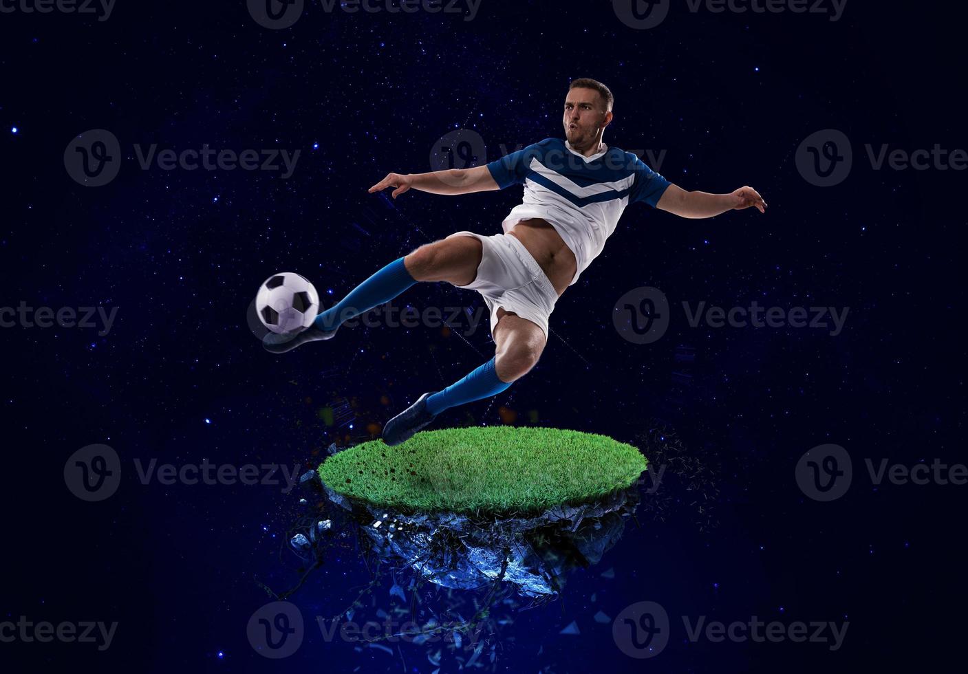 Football player kicks the soccer ball into space photo