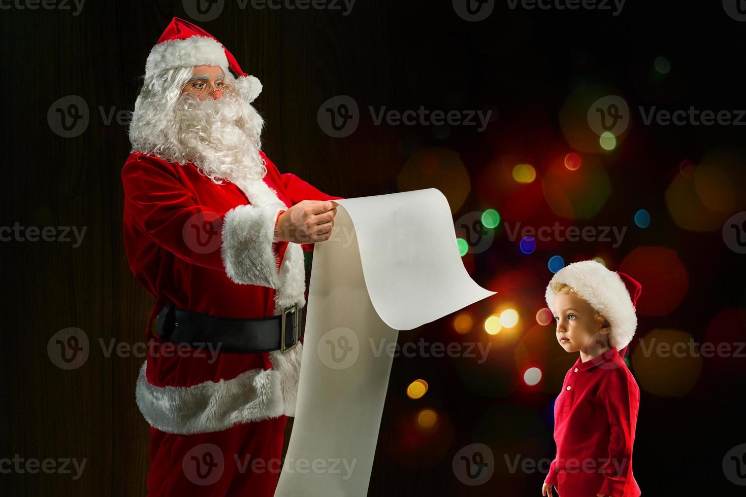 Santa Claus searches from a list a gift for a child photo