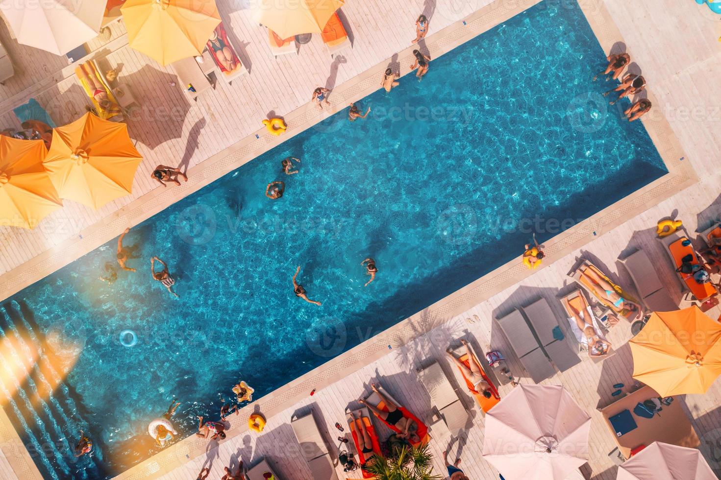 Drone view of people who relaxing in a swimming pool from photo