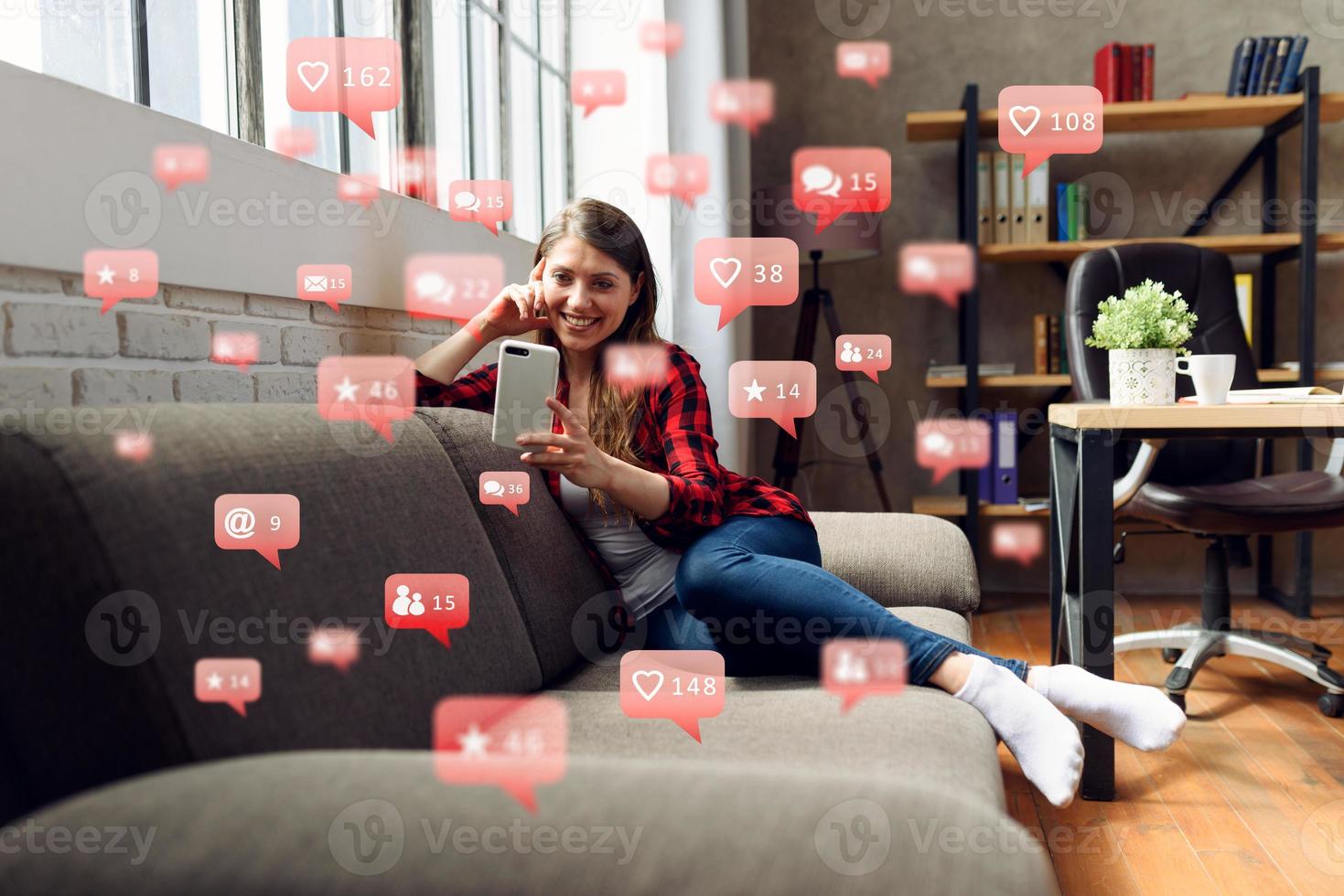 Happy woman chats via smartphone with social network messages, chat and users icons photo