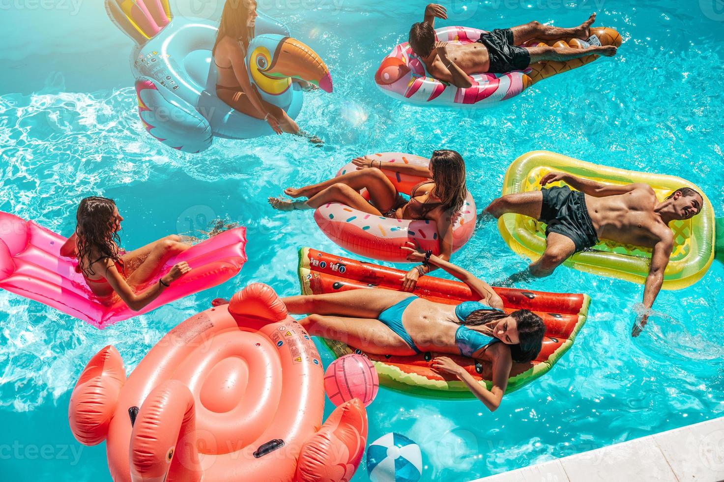 Friends in swimsuit in the pool getting a tan photo