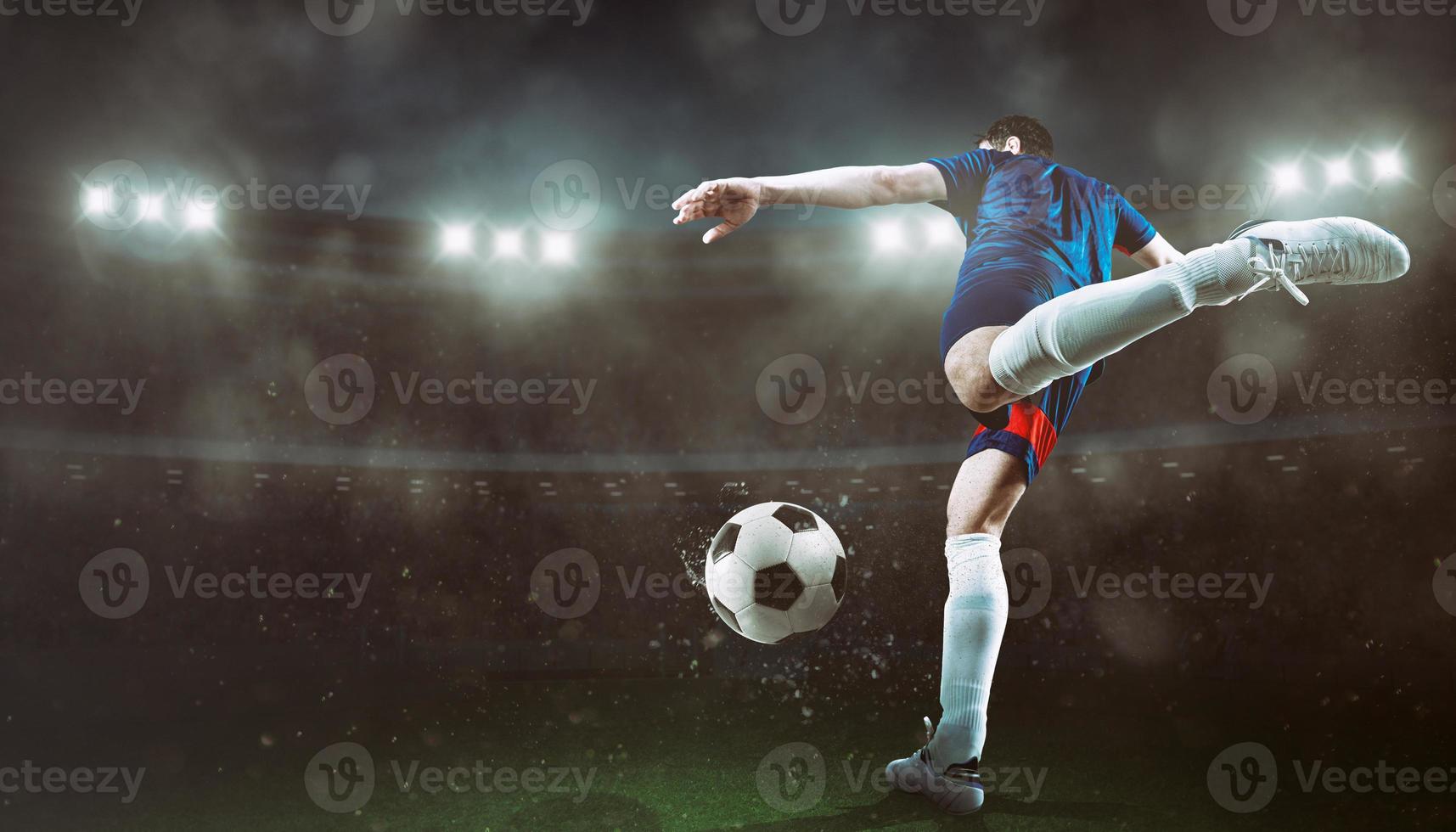 Football scene at night match with player kicking the ball with power photo