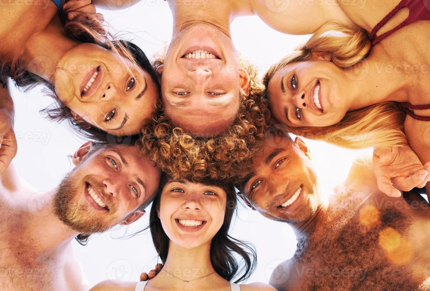 Happy group of friends in circle under the sun in the summertime photo