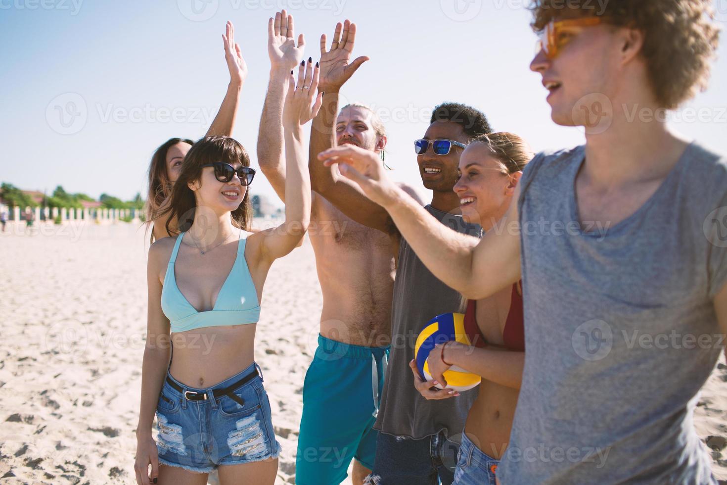 Group of friends playing at beach volley at the beach photo