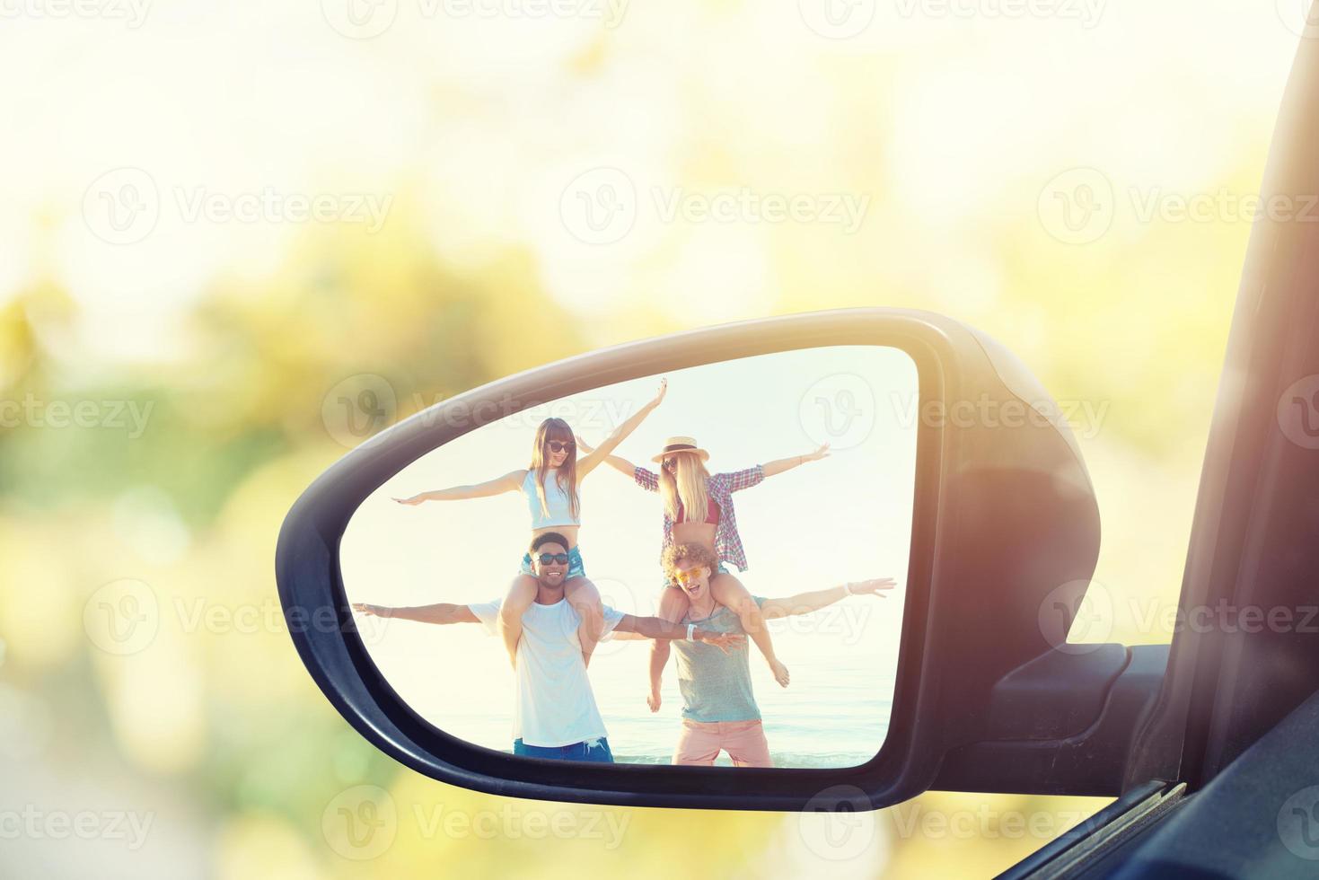 Wing mirror of a car with reflected a group of friends photo