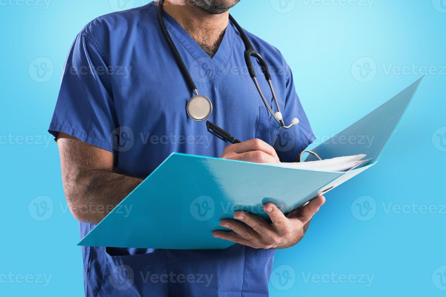 Doctor with stethoscope writes on medical record photo