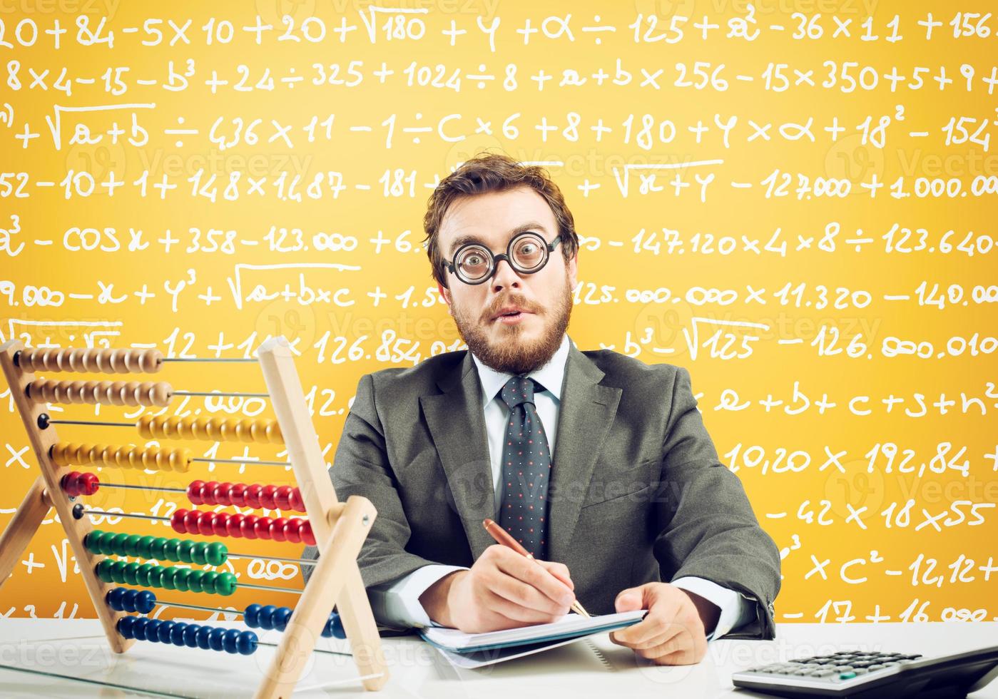 Nerd accountant does calculation of company revenue on yellow background photo