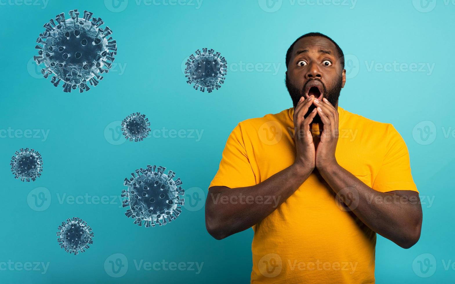Fearful expression of a boy who is scared to catch the coronavirus. Cyan background. photo