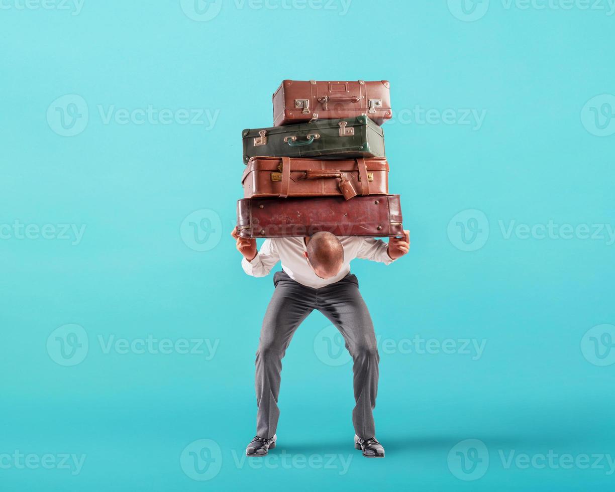 Man with a lot of luggages is exhausted and stressed to travel photo