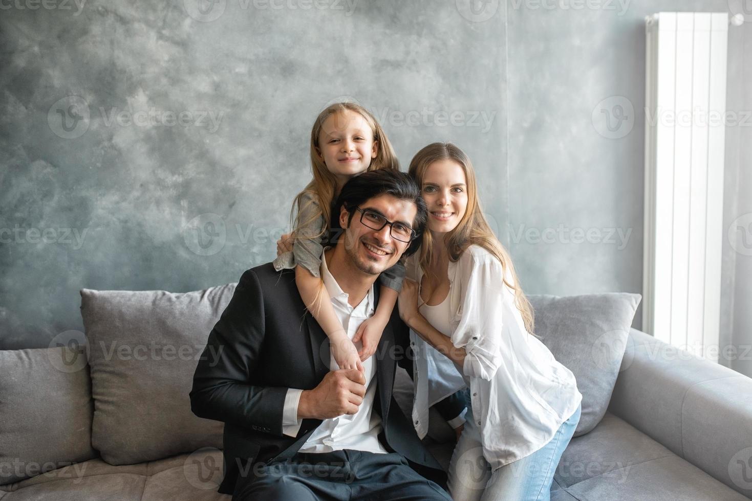 Happy little girl play with her mother and father photo