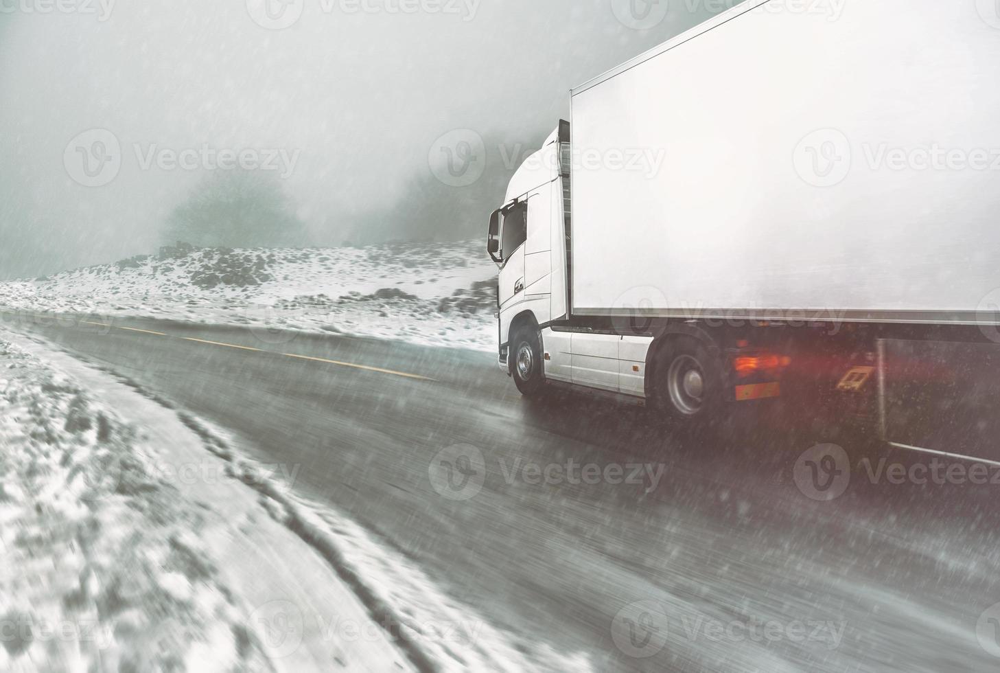 blanco moderno camión Moviente rápido en invierno en un la carretera con nieve foto