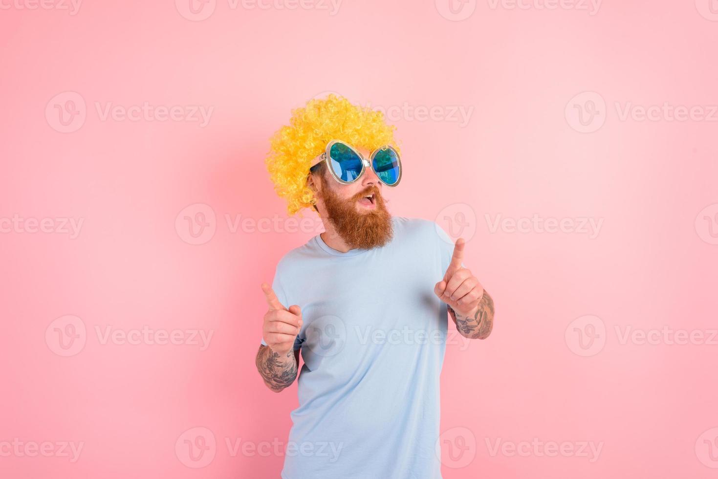 Funny man with peruke and sunglasses dances photo