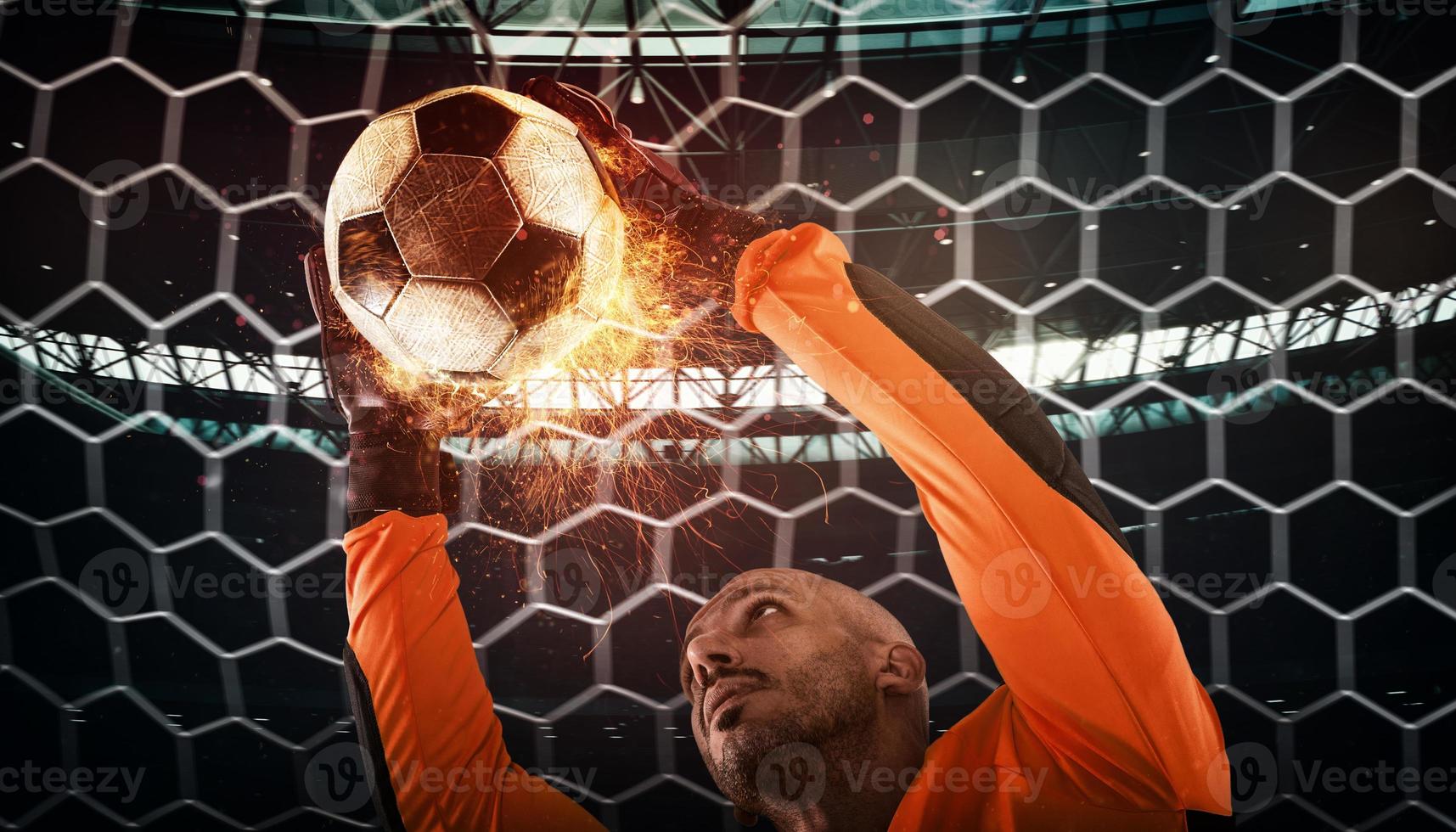 Close up of a soccer scene at night match with a goalkeeper trying to catch a fiery ball photo