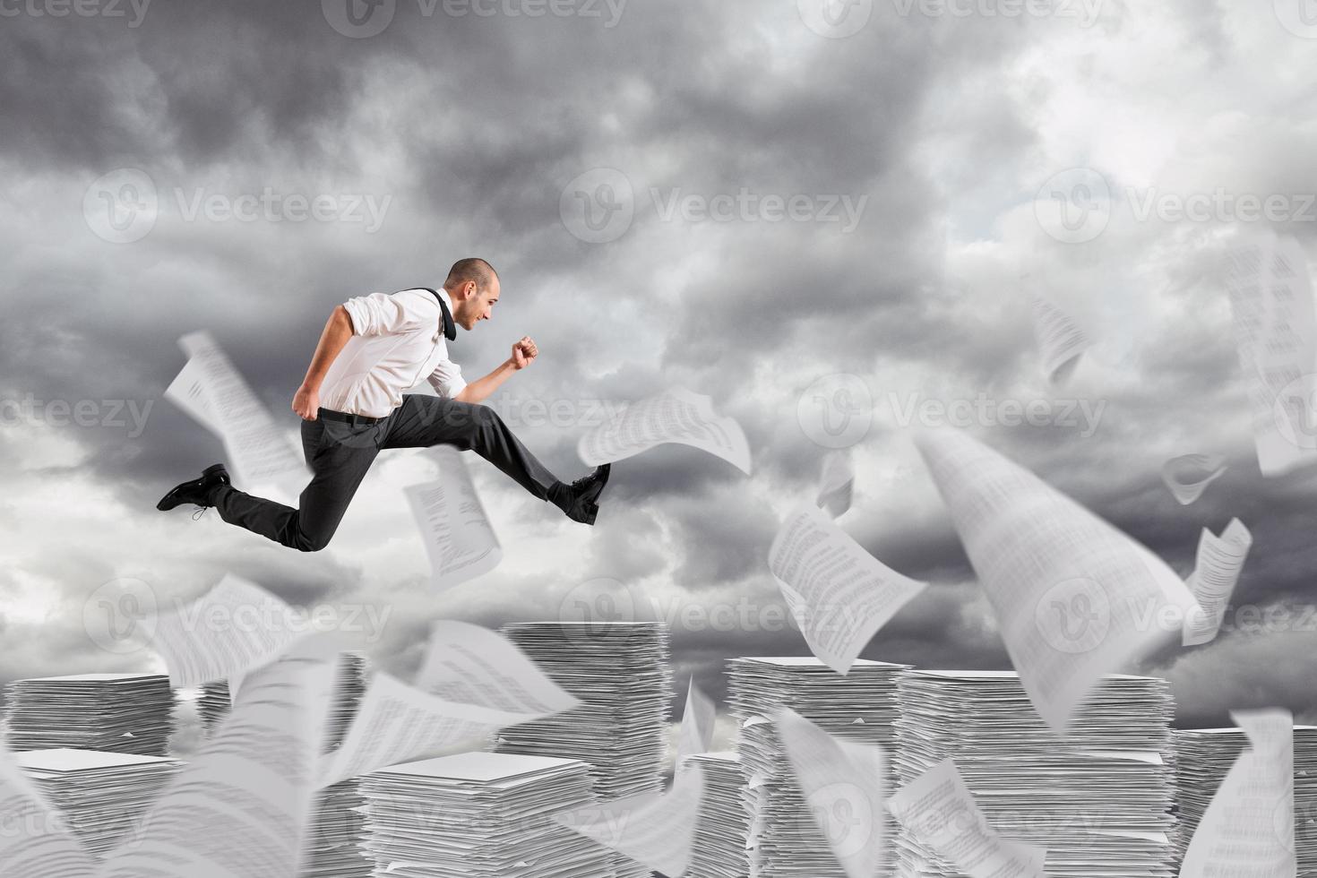 Businessman runs away from the worksheets and bureaucracy photo