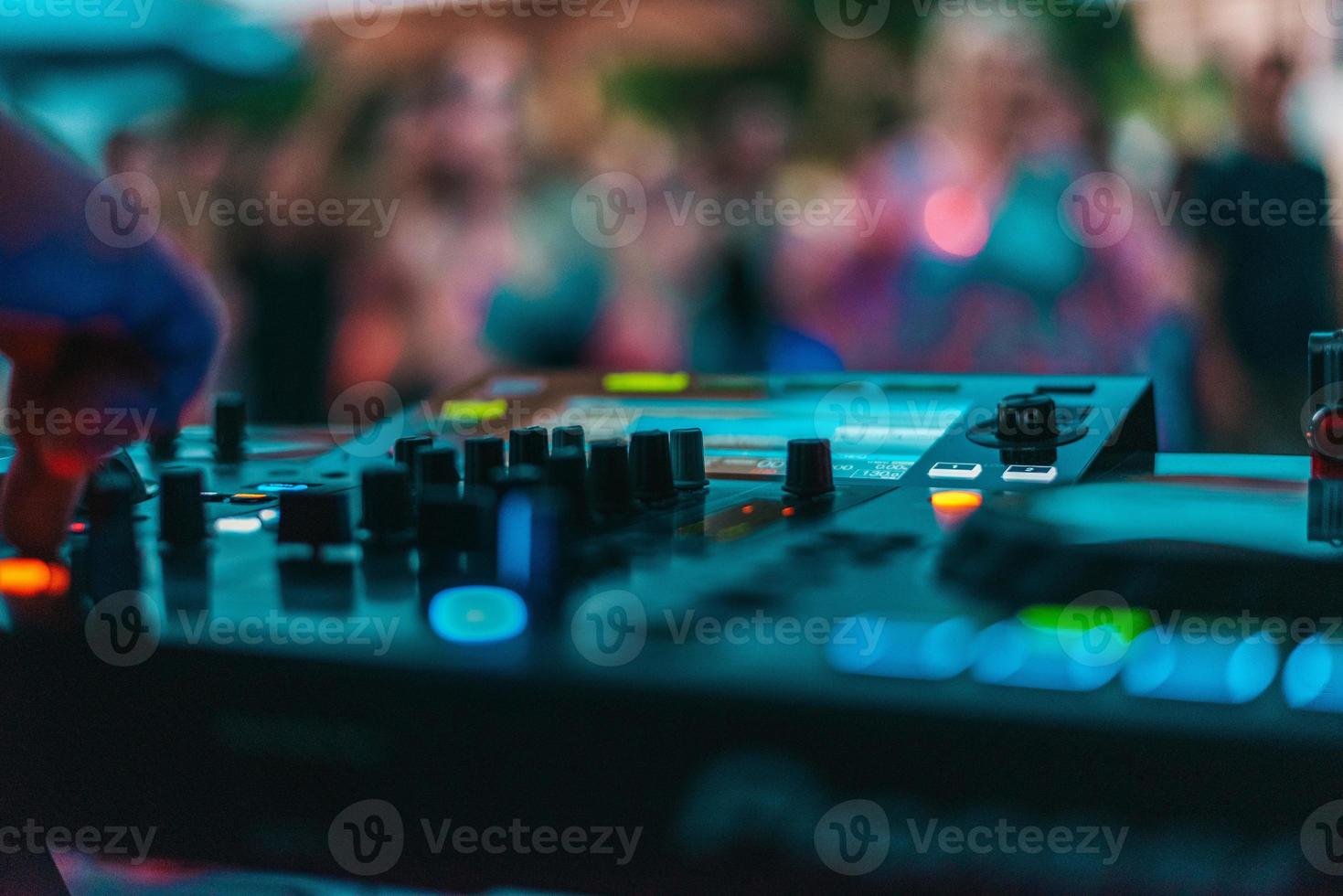 Dj plays disco music with his consolle in a pub photo