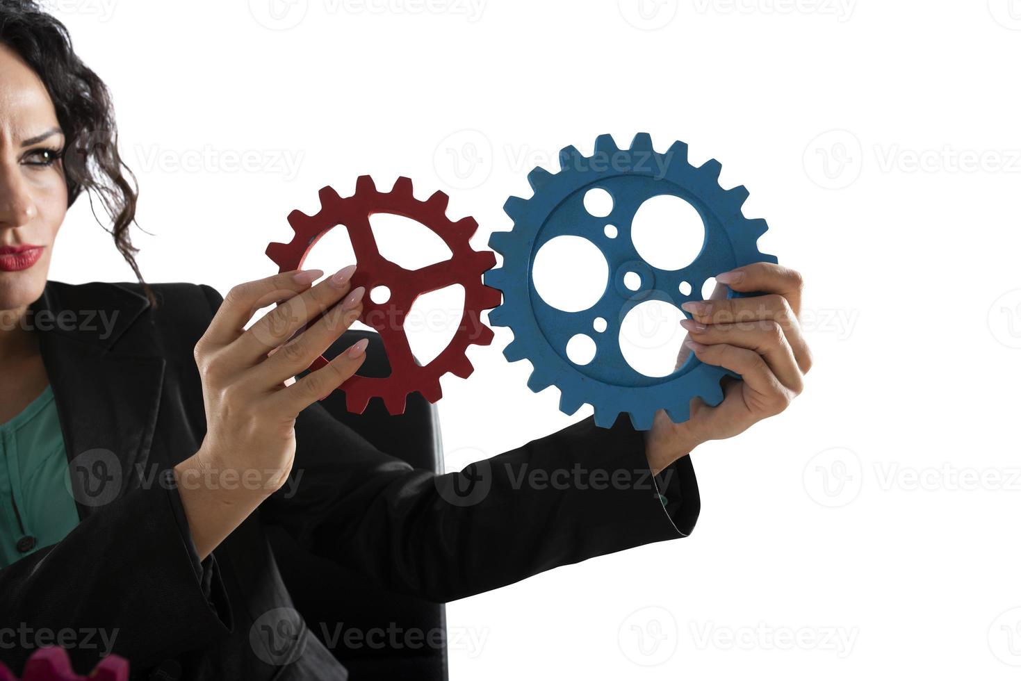 Businesswoman tries to connect gears pieces. Concept of Teamwork, partnership and integration photo