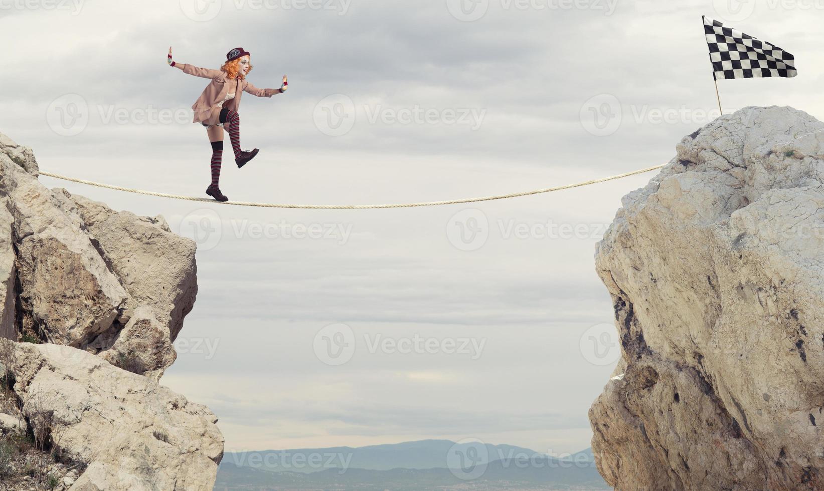 Clown girl wants to reach the flag over a rope photo