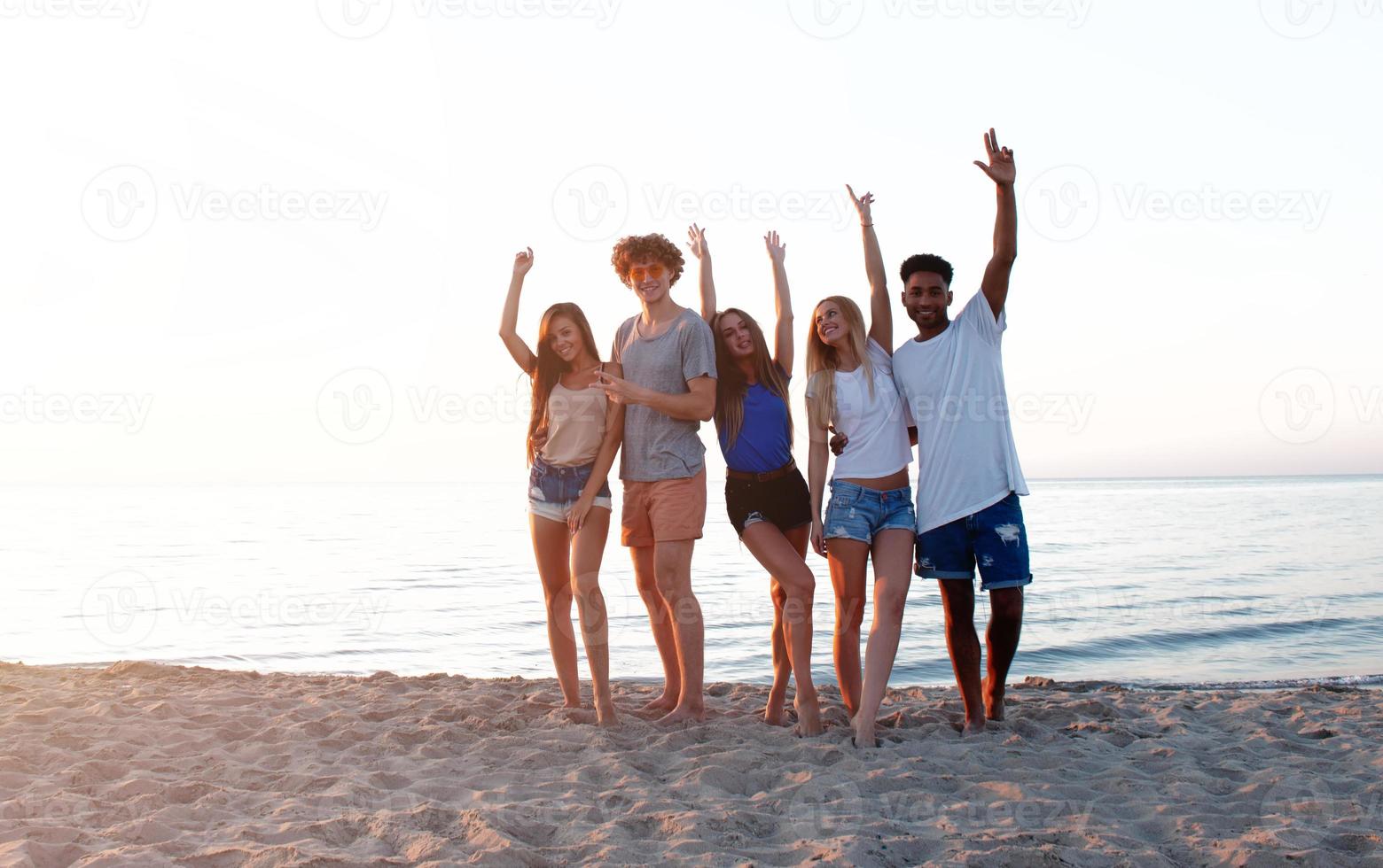 Group of friends having fun on the beach. Concept of summertime photo