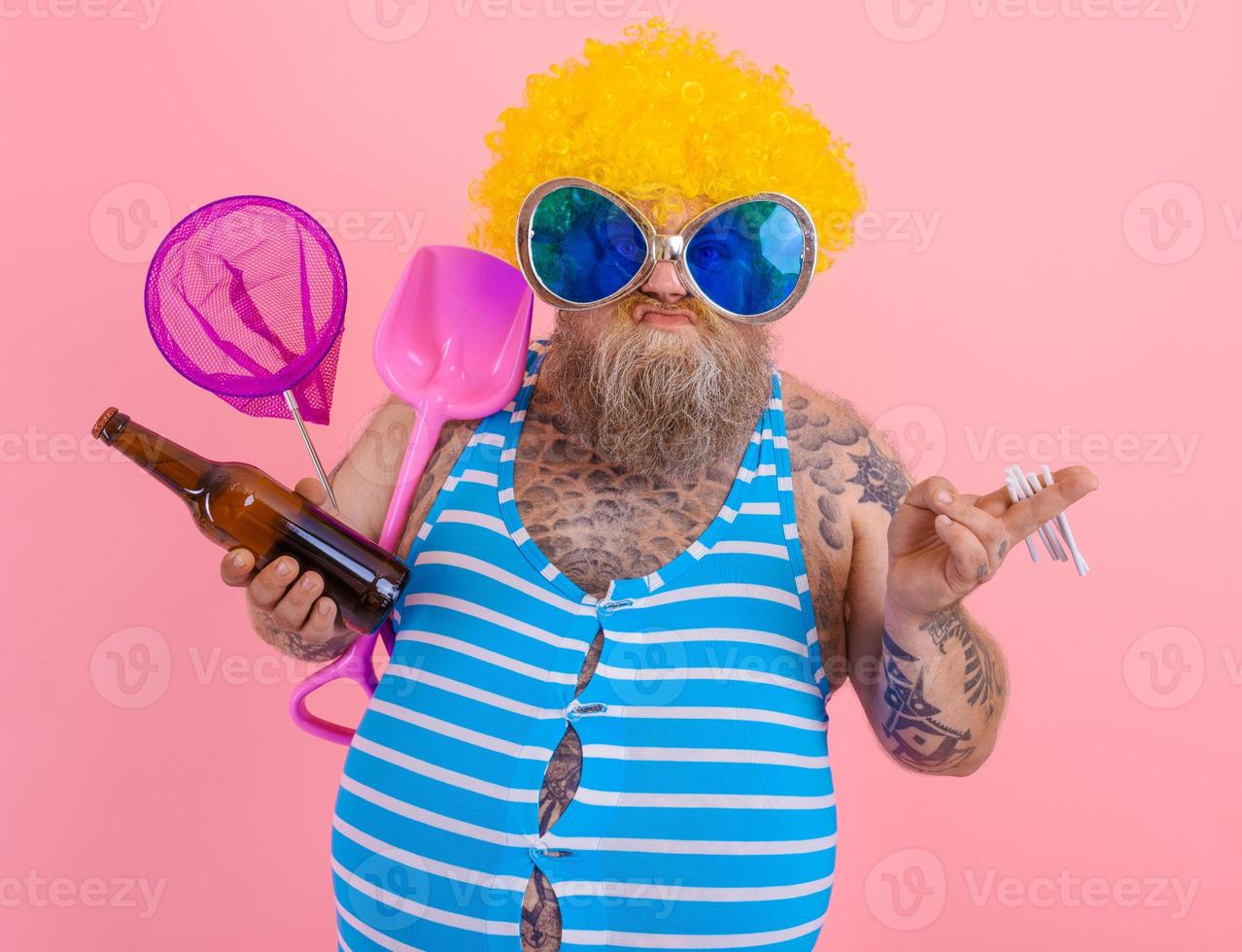 Fat man with beard and wig smokes cigarettes and drinks beer photo