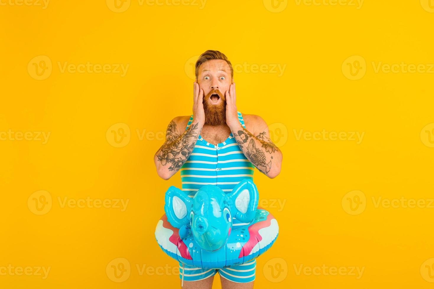 Amazed man with inflatable donut with elephant is ready to swim photo