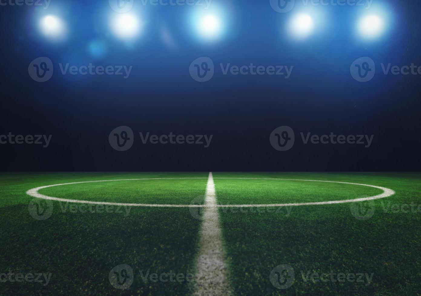Midfield of grass soccer field at night with headlights photo