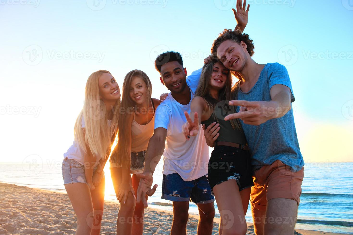 Group of friends having fun on the beach. Concept of summertime photo