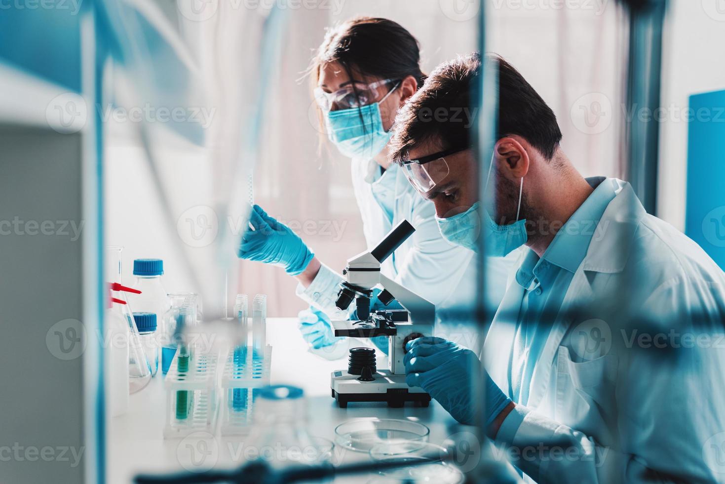 médico en el laboratorio análisis muestras de codiv-9 debajo un microscopio foto