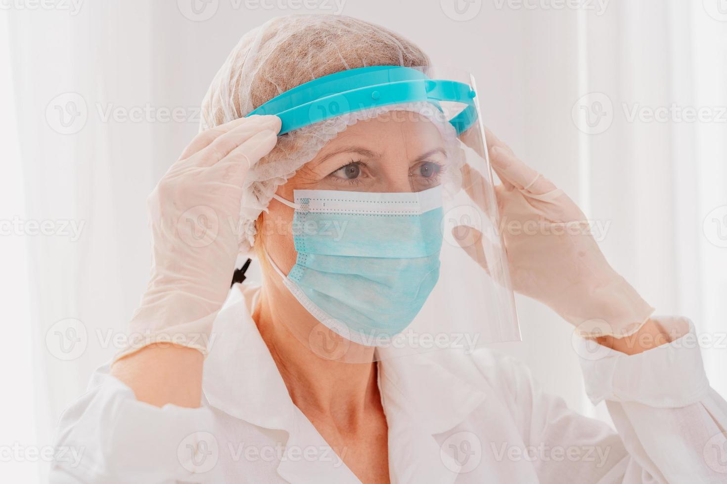 Doctor adjust the face protector screen against covid-19 virus photo