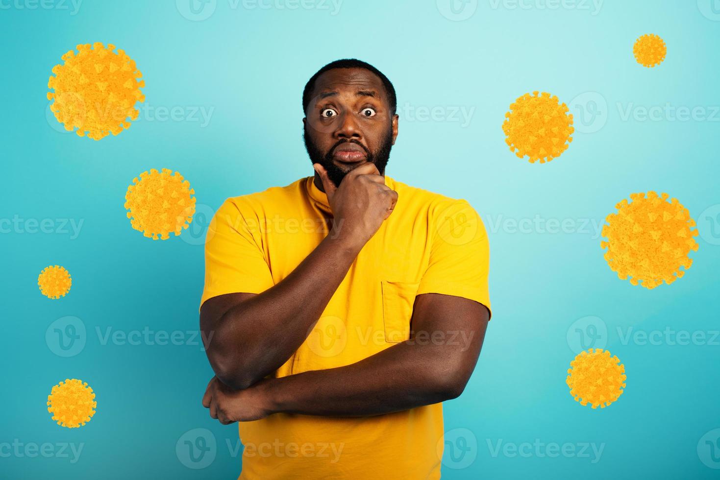 Fearful expression of a boy who is scared to catch the coronavirus. Cyan background. photo