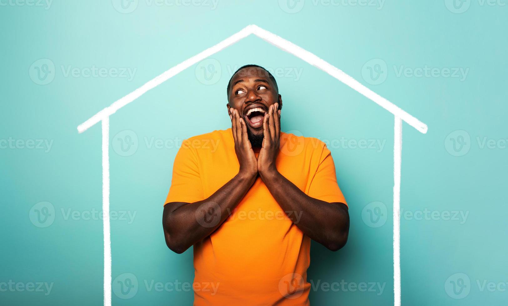 Man is amazed to have bought a house. Cyan background photo