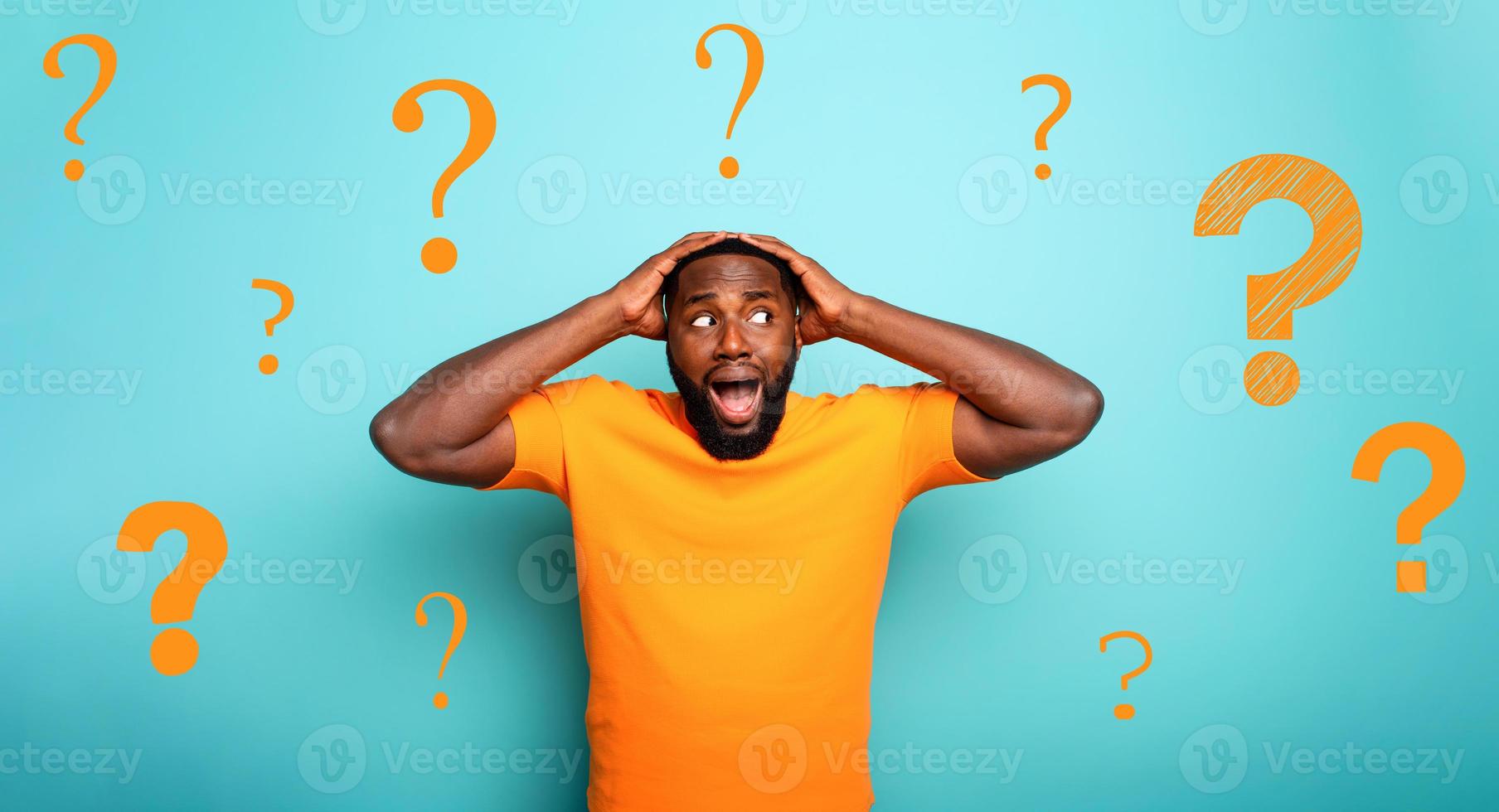 Feared and shocked expression of a boy with many questions . cyan colored background photo