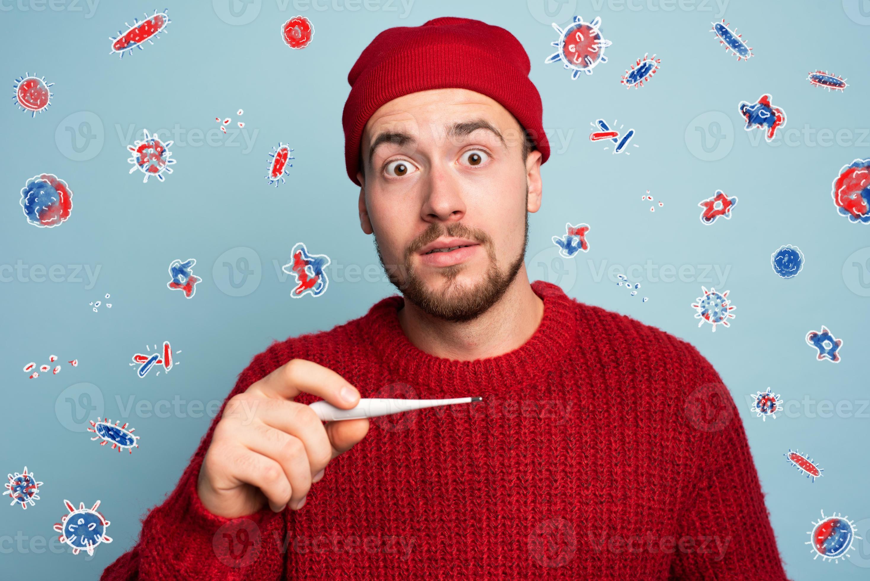 Boy caught a cold and measures the temperature with a thermometer