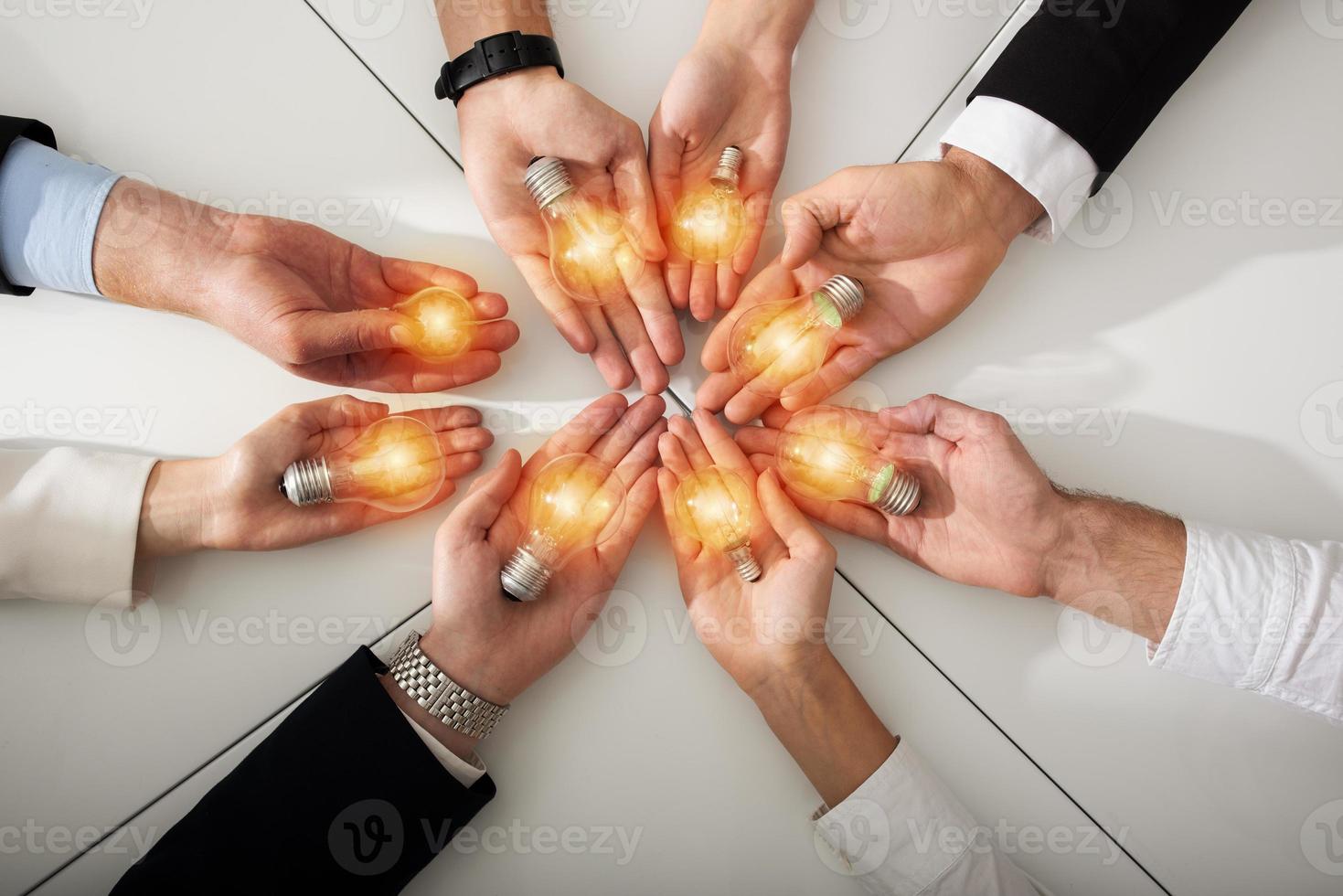 Teamwork and brainstorming concept with businessmen that share an idea with a lamp. Concept of startup photo