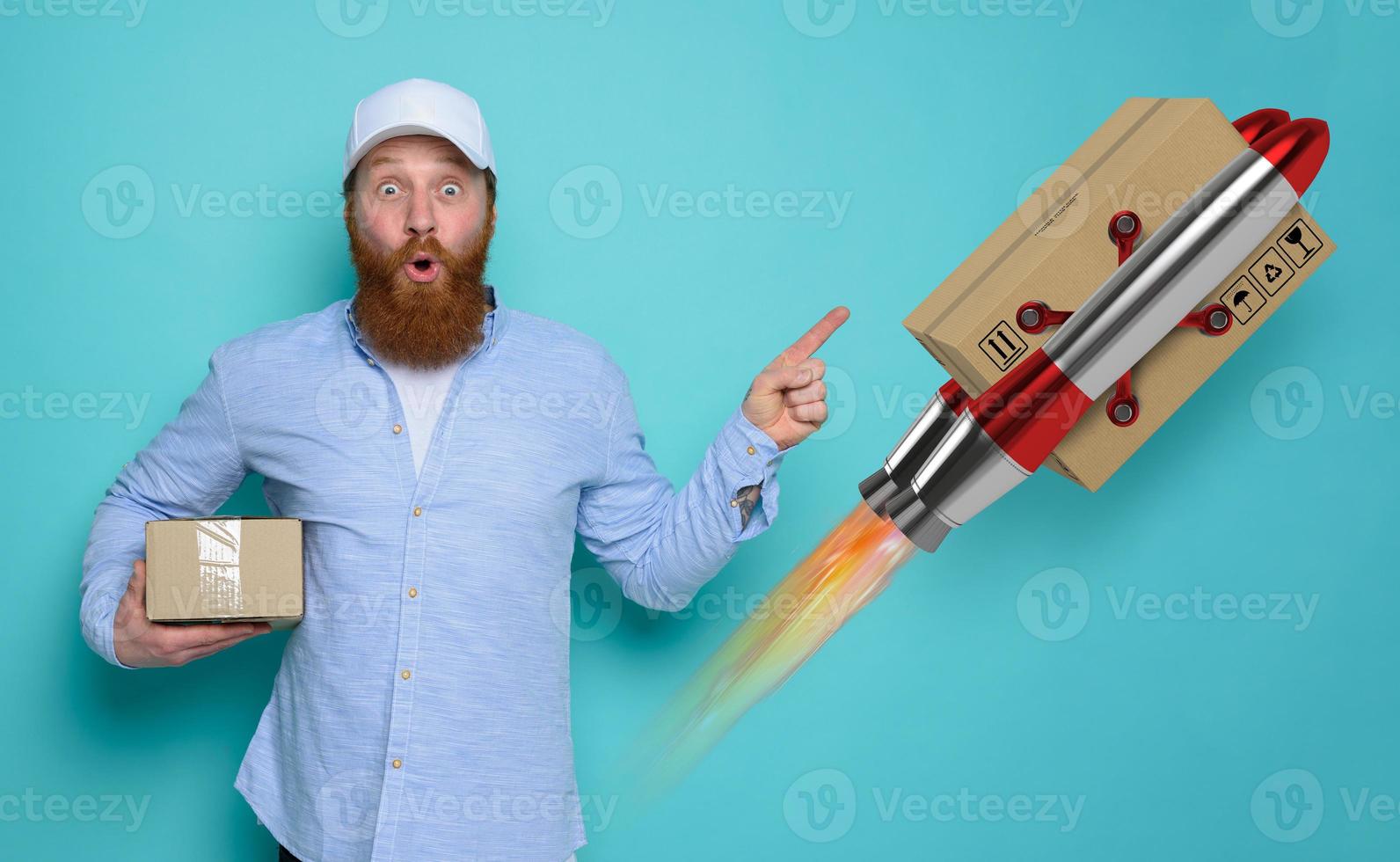 Courier man with surprised and amazed expression. concept of express and priority shipment. yellow background photo