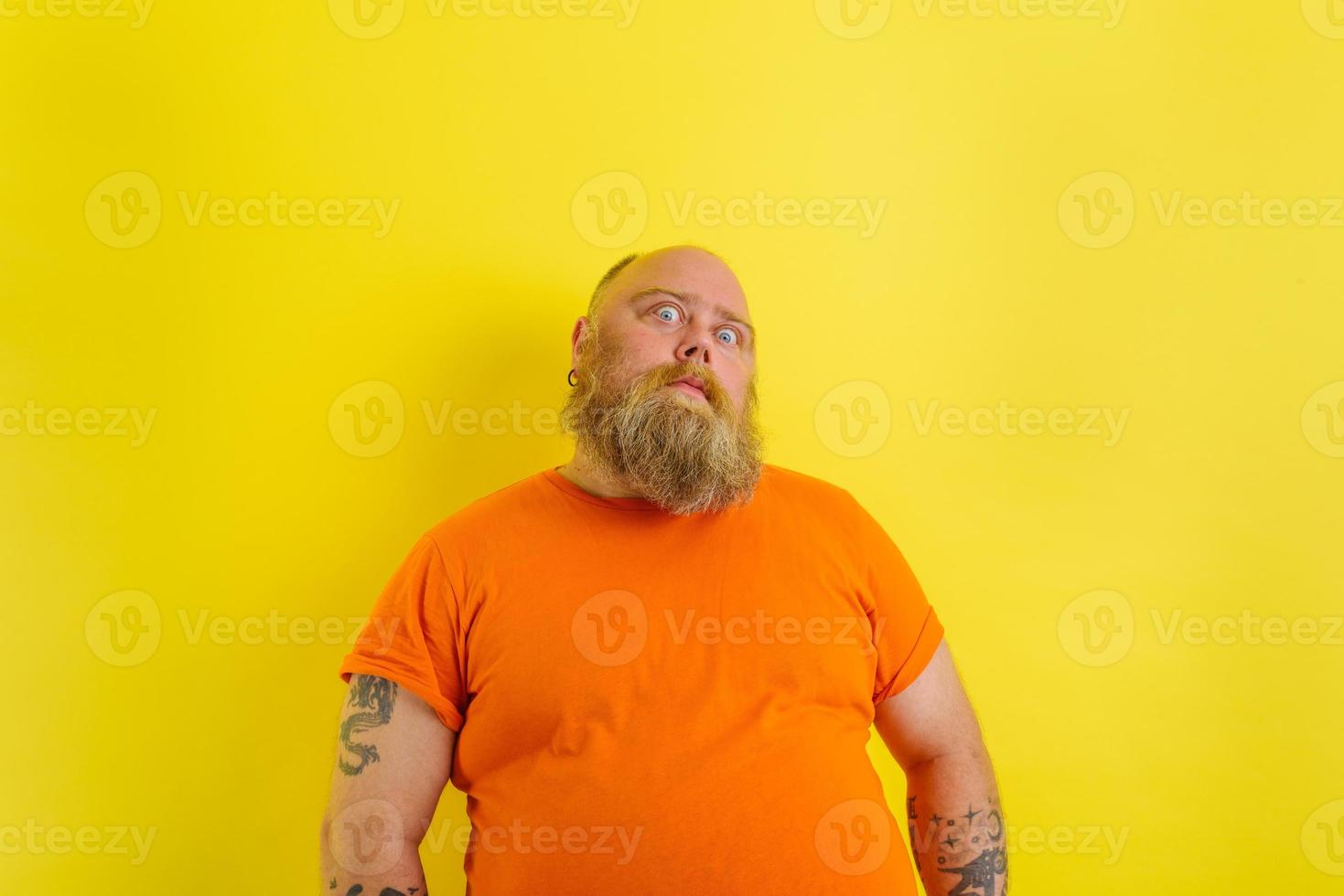 Man with beard and tattoos has a serious expression photo