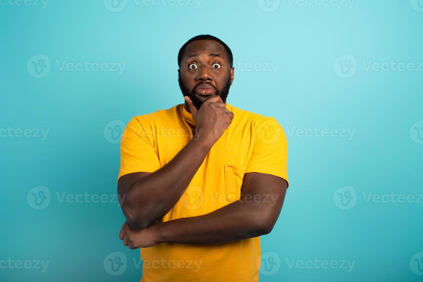 Confuse and pensive expression of a boy with many questions . cyan colored background photo