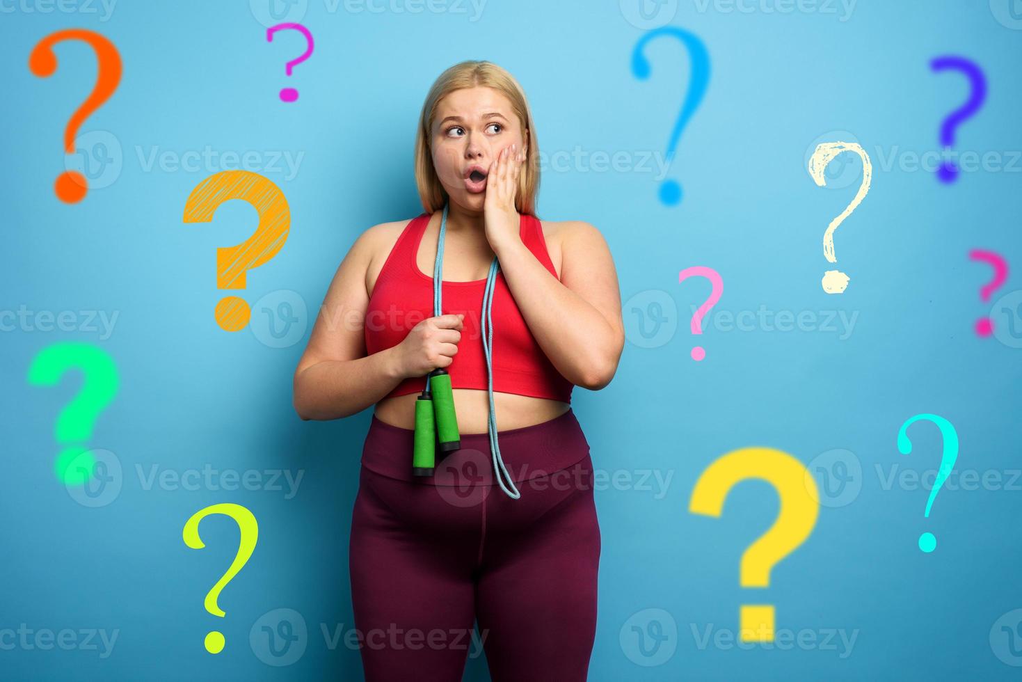 Fat girl does gym but is worried due to lot of questions. cyan background photo