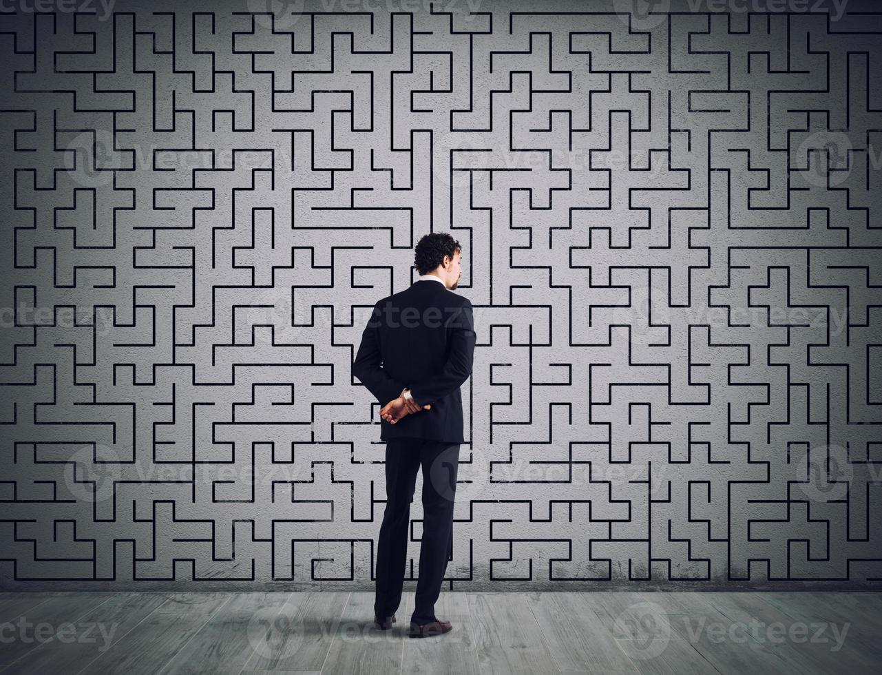 Businessman draws the solution of a labyrinth. Concept of problem solving photo