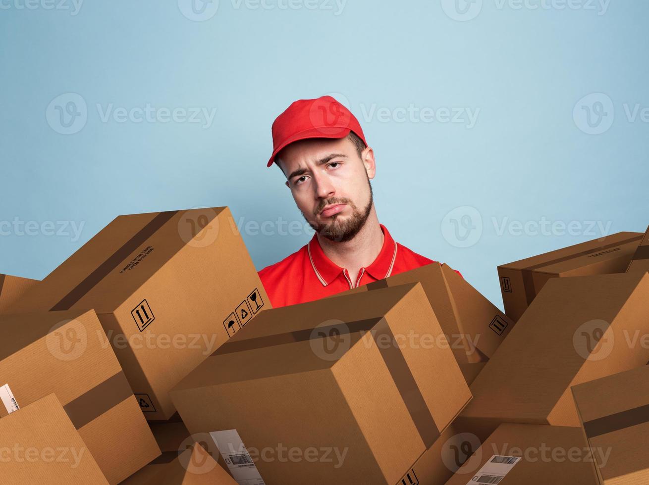 Courier is confused due to a lot of packages to deliver. concept of overwork and growth internet order. Cyan color background photo