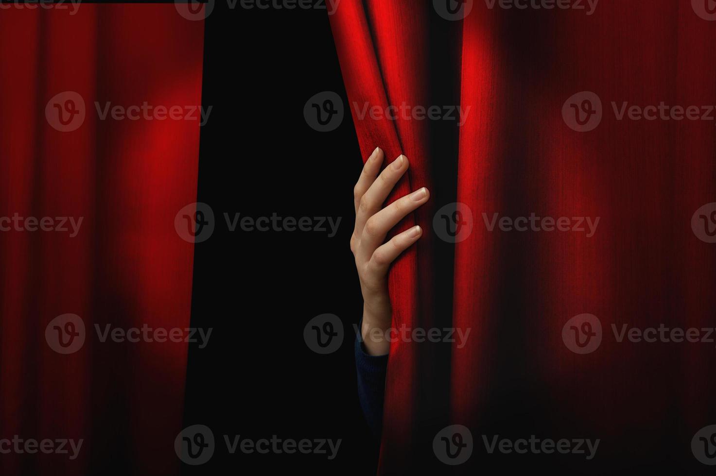 Girl opens red curtain of a theater. The show can starts photo